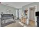 Comfortable bedroom with neutral tones, a dark-colored crib, and a peek into the en-suite bathroom at 322 Wax Myrtle Ct, Cary, NC 27513