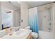 Bathroom featuring a shower over tub with blue curtain, a toilet, and sink with mirror at 3349 Tarleton W, Durham, NC 27713