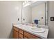 Bathroom with double sinks and large mirror above wood vanity at 3349 Tarleton W, Durham, NC 27713