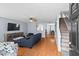 Inviting living room with wood floors, a comfortable blue sofa, and easy access to the staircase at 3349 Tarleton W, Durham, NC 27713