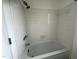 Bright bathroom featuring a bathtub with white tiles, sleek fixtures, and a shower head at 3412 Rock Creek Dr, Raleigh, NC 27609