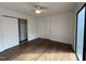 Bedroom featuring hardwood floors, closet with sliding doors, and a bright window for plenty of light at 3412 Rock Creek Dr, Raleigh, NC 27609