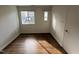 White bedroom with two bright windows for great natural light and gleaming hardwood floors at 3412 Rock Creek Dr, Raleigh, NC 27609