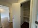 Open closet featuring wooden floors, multiple shelves, and a doorway to another room at 3412 Rock Creek Dr, Raleigh, NC 27609