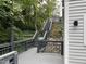 Exterior view of deck with gray wood railings and stairs leading to backyard with retaining wall at 3412 Rock Creek Dr, Raleigh, NC 27609