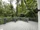 Wood deck with grey railings and a backdrop of green trees and string lights at 3412 Rock Creek Dr, Raleigh, NC 27609