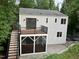 Exterior of home featuring a wood deck, screened porch and stone patio, surrounded by lush trees at 3412 Rock Creek Dr, Raleigh, NC 27609