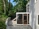 View of backyard patio and balcony with black metal railings on gray siding with screened-in porch at 3412 Rock Creek Dr, Raleigh, NC 27609