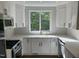 Bright kitchen with modern appliances, white cabinets, subway tile backsplash, and a window view of lush greenery at 3412 Rock Creek Dr, Raleigh, NC 27609
