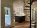 Modern kitchen with stainless steel appliances and a stylish island, adjacent to a spiral staircase at 3412 Rock Creek Dr, Raleigh, NC 27609