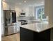 Modern kitchen with stainless steel appliances, white cabinets, and a central island at 3412 Rock Creek Dr, Raleigh, NC 27609