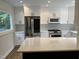 Spacious kitchen featuring white cabinets, stainless steel appliances, a center island, and a view to the backyard at 3412 Rock Creek Dr, Raleigh, NC 27609