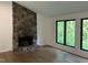 Living room featuring a stunning stone fireplace, hardwood floors, and large picture windows at 3412 Rock Creek Dr, Raleigh, NC 27609