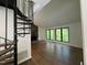 Open-concept living area with a unique spiral staircase, stone fireplace, and large windows at 3412 Rock Creek Dr, Raleigh, NC 27609