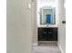 Modern bathroom with a dark vanity, decorative mirror, and tile flooring at 4100 Five Oaks Dr # 50, Durham, NC 27707