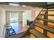 Open floor plan with deck access, cozy chairs, fireplace, and staircase to the next level at 4100 Five Oaks Dr # 50, Durham, NC 27707