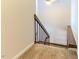 A carpeted staircase features a dark brown handrail and black iron balusters at 4100 Five Oaks Dr # 50, Durham, NC 27707