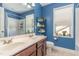 Bathroom featuring a double vanity, large mirror, and blue accent wall at 4204 Vineyard Ridge Dr, Zebulon, NC 27597