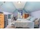 Attic bedroom featuring a cozy bed, storage options, and a sloped ceiling with unique blue and purple decor at 4204 Vineyard Ridge Dr, Zebulon, NC 27597