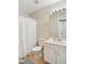 Bathroom showcasing white cabinets, sink, and a shower-tub with a white shower curtain at 4555 Sugarbend Way, Raleigh, NC 27606