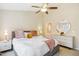 Neutral bedroom with ceiling fan, closet access, and dresser with round mirror above at 4555 Sugarbend Way, Raleigh, NC 27606