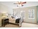 Cozy bedroom with carpet and a large window showcasing a view of the surrounding greenery at 4555 Sugarbend Way, Raleigh, NC 27606