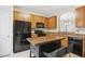 Functional kitchen featuring an island, black appliances, wood cabinets and plenty of counter space at 4555 Sugarbend Way, Raleigh, NC 27606