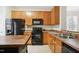 Functional kitchen featuring an island, black appliances, wood cabinets and ample counter space at 4555 Sugarbend Way, Raleigh, NC 27606