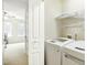 Well-lit laundry room featuring modern washer and dryer units and convenient shelving at 4555 Sugarbend Way, Raleigh, NC 27606