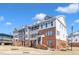 A row of townhomes with brick and vinyl siding with a landscaped yard and sidewalk at 507 Gateway Townes Blvd, Wake Forest, NC 27587