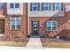 Brick townhouse with a black front door, a small garden, and matching trimmed windows at 507 Gateway Townes Blvd, Wake Forest, NC 27587