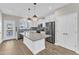 Modern kitchen with gray backsplash, island, stainless steel appliances, and white cabinets at 507 Gateway Townes Blvd, Wake Forest, NC 27587