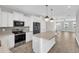 Open kitchen with island, stainless appliances, granite countertops, and adjacent living area at 507 Gateway Townes Blvd, Wake Forest, NC 27587