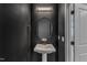 Stylish powder room featuring a pedestal sink, modern lighting, and dark accent wall at 507 Gateway Townes Blvd, Wake Forest, NC 27587