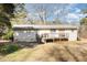 View of the home's backyard with a wooden deck and stairs leading to a large lawn at 5848 Yates Mill Pond Rd, Raleigh, NC 27606