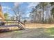 Spacious backyard featuring a wooden deck and stairs to the expansive lawn at 5848 Yates Mill Pond Rd, Raleigh, NC 27606