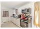 Well-lit kitchen featuring white cabinets, a stainless steel oven, and sleek appliances at 5848 Yates Mill Pond Rd, Raleigh, NC 27606