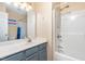 Bathroom with a blue vanity, well-lit mirror, and a shower-tub combination at 5915 Eaglesfield Dr, Raleigh, NC 27613