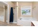 Bathroom featuring a soaking tub and separate shower, all illuminated by a window at 5915 Eaglesfield Dr, Raleigh, NC 27613