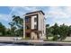 Modern three-story home with light siding, dark trim, and stone accents, complemented by professional landscaping at 615 Velma Hopkins Ln, Raleigh, NC 27603