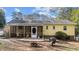 Rear exterior of the house with a screened in porch, patio, fire pit, and backyard at 6404 Dixon Dr, Raleigh, NC 27609