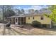 View of a spacious backyard, screened-in porch, wooden walkway, and yellow siding at 6404 Dixon Dr, Raleigh, NC 27609