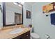 Stylish bathroom with granite countertop vanity, framed mirror, and art at 6404 Dixon Dr, Raleigh, NC 27609