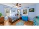 Bedroom with hardwood floors, ceiling fan, two windows, and a blue trunk at 6404 Dixon Dr, Raleigh, NC 27609