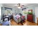 Cozy bedroom with two windows, ceiling fan, hardwood floors, and workout bike at 6404 Dixon Dr, Raleigh, NC 27609