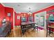 Farmhouse dining room with red walls, wood floors, bench seating, and vintage decor, exudes rustic charm at 6404 Dixon Dr, Raleigh, NC 27609