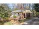 A side view of brick home with mature landscaping, trimmed front yard, and mature trees in the landscaping at 6404 Dixon Dr, Raleigh, NC 27609