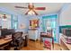 Bright home office with hard wood floors, computer, white drawers and a large tropical-themed art painting at 6404 Dixon Dr, Raleigh, NC 27609