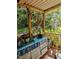 Screened porch with a painted dresser and a garden view, blending indoor comfort with outdoor beauty at 6404 Dixon Dr, Raleigh, NC 27609