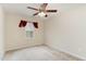 Neutral bedroom features a ceiling fan, plush carpeting, and a large window with red drapes at 705 Keystone Park Dr # 51, Morrisville, NC 27560
